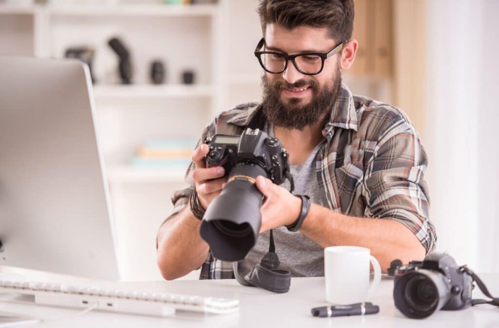 As a creative entrepreneur you can totally love your work. A photographer looks at images on his camera.