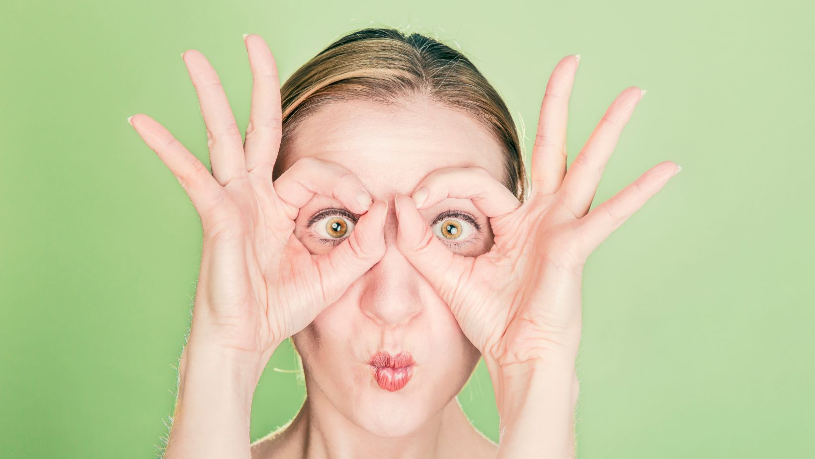 Woman using her hands to make the shape of a binoculars | How to find a web developer in Amherst MA