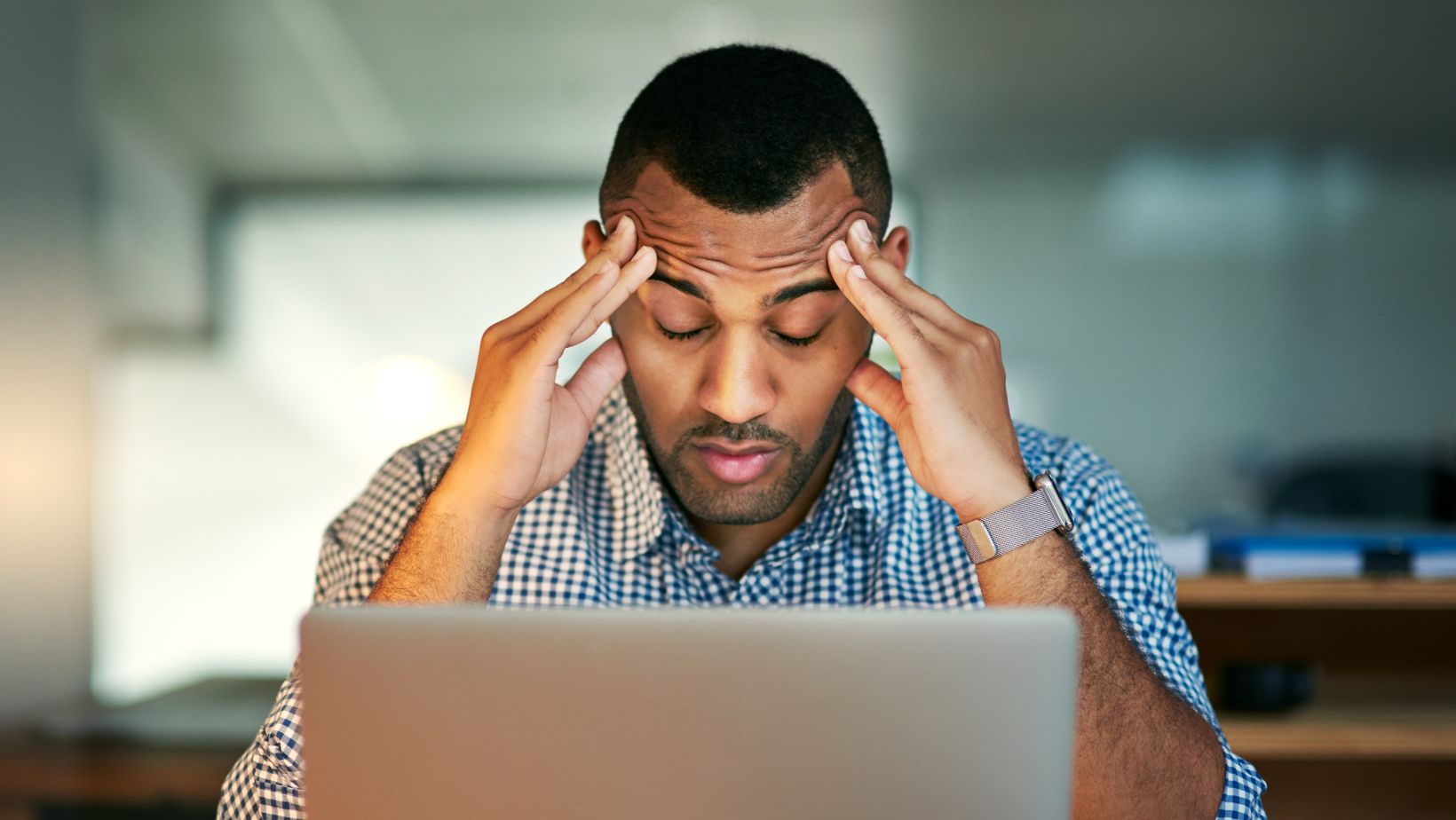 Man stressed looking at his laptop
